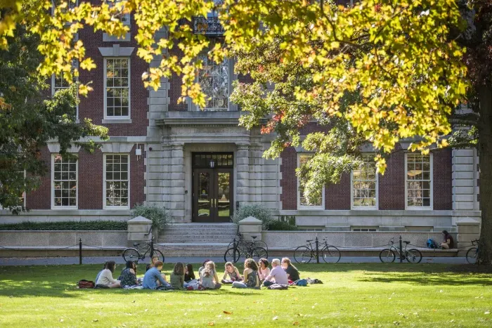 学生 sitting on the lawn in front of Seelye Hall.